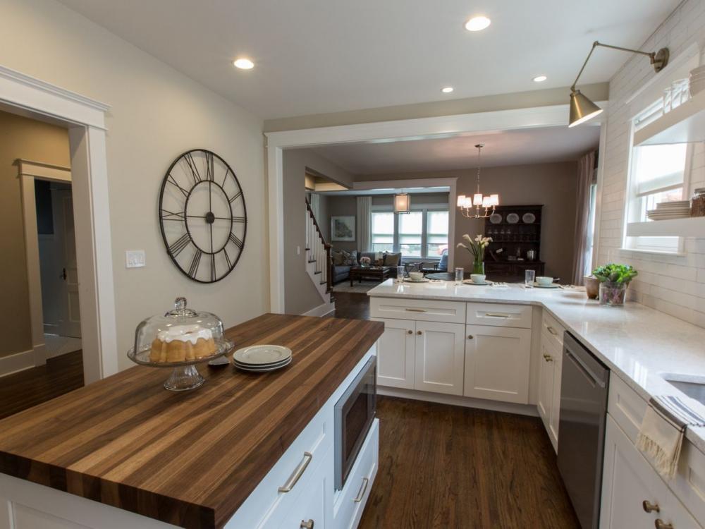A kitchen featuring a wooden countertop and white cabinets, creating a bright and inviting cooking space.
